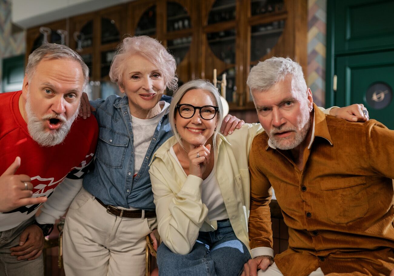 Groupe de seniors souriants illustrant le bien-être psychologique, le lien social et le bien vieillir lors d'un programme de prévention en santé mentale.