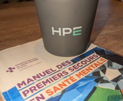 Manuel Premiers Secours en Santé Mentale et mug Hewlett Packard Enterprise lors d'une formation PSSM à Grenoble.
