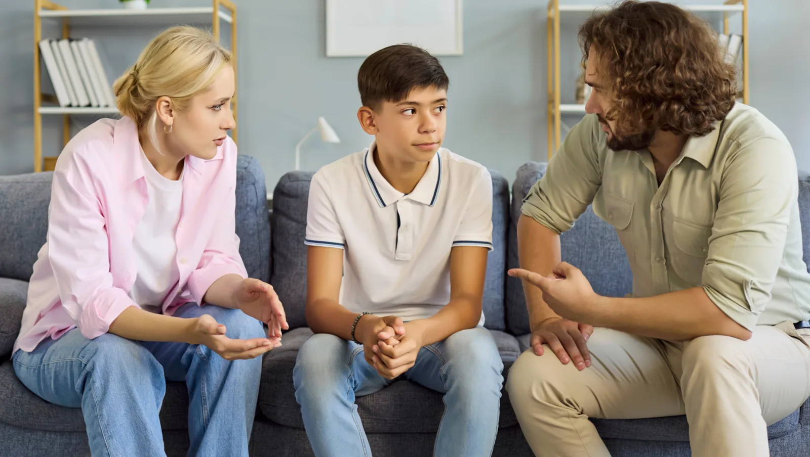 Un adolescent échange avec deux adultes assis à ses côtés