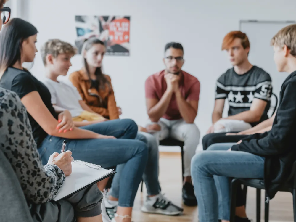 Un groupe de jeunes échange avec une adulte dans un cadre collectif